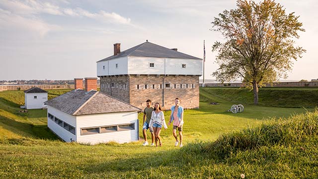 Three young adults exploring the grounds of Fort Wellington National Historic Site