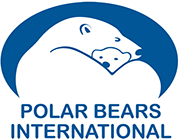 À l’intérieur d’un ovale bleu, un ours polaire adulte regarde vers la droite. Dans ses bras est recroquevillé un ourson qui regarde vers nous. La tête de l’ourson polaire se détache du corps de l’ours adulte. En dessous, le texte en bleu indique Polar Bears International.