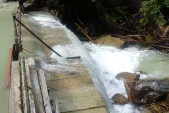 A concrete barrier (weir) with a stream flowing over it.