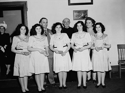 Les quintuplées Dionne, accompagnées de Mme Olive Dionne et du frère Gustave Sauvé, prenant part à un programme de musique religieuse au parc Lansdowne, durant le Congrès marial de cinq jours où l'on a prié pour la paix et célébré le centenaire de l'archi © National Film Board of Canada | Office national du film du Canada. Photothèque / Library and Archives Canada | Bibliothèque et Archives Canada / PA-155518