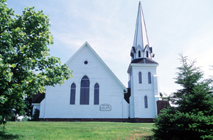 View of the exterior of Tryon United Church, showing its simple, bold form and composition, including its prominent, almost freestanding tower, and its massive, uninterrupted horizontal surfaces, 1995. © Parks Canada Agency / Agence Parcs Canada, J. Butterill, 1995.