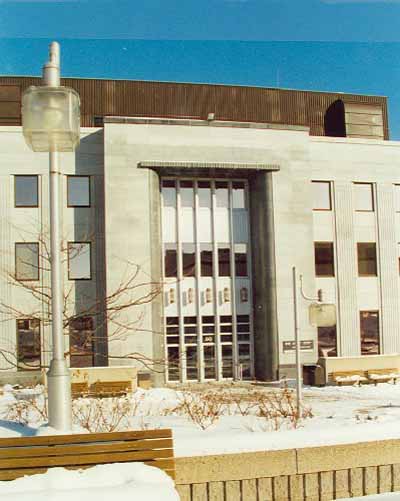 View of the main entrance to the Federal Building in Sherbrooke, showing accent features inspired by Art Deco design such as the copings, curved entrance returns and ribbed canopy projections, 1995. © Public Works and Government Services Canada / Travaux publics et Services gouvernementaux Canada, 1995.