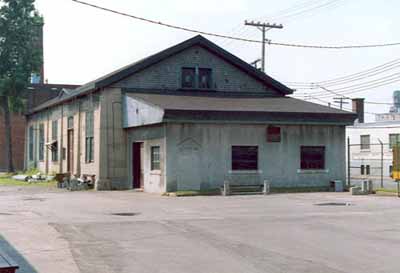 Vue en angle de l'atelier d'usinage, qui montre l’emploi de matériaux durables, comme l’acier et le béton, 1990. (© Agence Parcs Canada / Parks Canada Agency, 1990.)