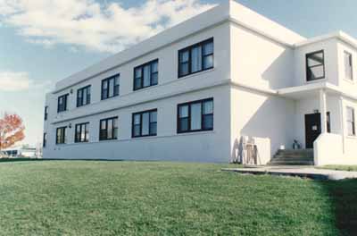 View of the exterior of Building B-39, showing the concrete construction with white painted stucco cladding, 1993. © Parks Canada Agency / Agence Parcs Canada, 1993.