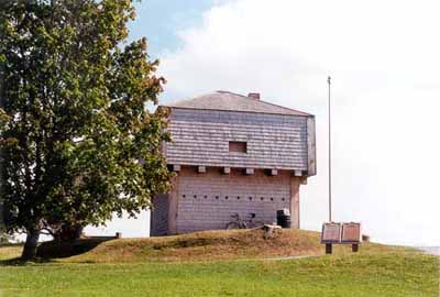 General view of the rear and side elevations of the St. Andrews Blockhouse showing the simple, well-proportioned, geometric massing of the squat square profile with a pyramidal roof, 1998. © Parks Canada Agency/ Agence Parcs Canada, 1998.