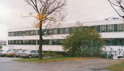 General view of Building M-12, showing the reinforced concrete construction and white stucco clad exterior walls, 1990. © National Research Council Canada / Conseil national de recherches du Canada, 1990.