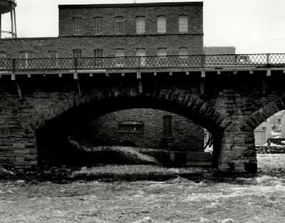 View of the East Mill, showing the exterior walls of uncoursed limestone blocks, 1972. © Agence Parcs Canada / Parks Canada Agency, 1972.