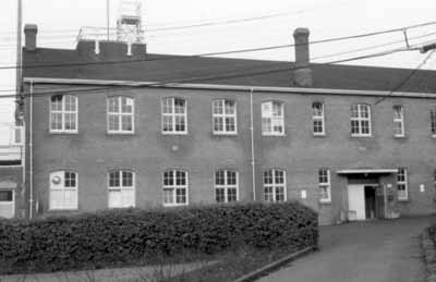 Vue générale du bâtiment D77, ancien dépôt de munitions, qui montre les grandes fenêtres cintrées régulièrement espacées, 1970. © (CIHB/IBHC, Parks Canada/Parc Canada, 1970)