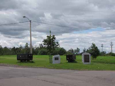 General view of the Historical Sites and Monuments Board of Canada's plaques on the empty field near where the entrances to the mines stood commemorating the Springhill Coal Mining site, 2010. © Parks Canada Agency / Agence Parcs Canada