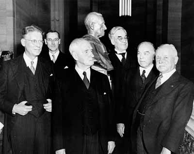 (L.-R.:) Hon. J.L. Ilsley, J.C. McRuer, K.C., Sir Lyman Duff, John T. Hackett, K.C., Rt. Hon. W.L. Mackenzie King, Rt. Hon. Thibodeau Rinfret, Chief Justice of Canada © T.V. Little / Library and Archives Canada | Bibliothèque et Archives Canada / PA-134980