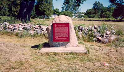 General view of the commemorative plaque and outlining rock walls of Fort Sainte Marie II National Historic Site of Canada, 1989. © Parks Canada Agency / Agence Parcs Canada, 1989.