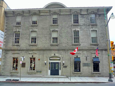 General view of the main facade of the Former Geological Survey of Canada Building showing its modest classically inspired ornamentation including semi-arched window lintels, keystones, broad stone stringcourses, stone quoins, 2011. © Parks Canada Agency / Agence Parcs Canada, M. Therrien, 2011.