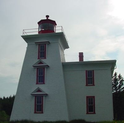 General view of the Light Tower and Dwelling, showing the massing which is comprised of a square, tapered medium-height tower attached to an adjoining two-storey residence, finished with a flat roof. (© Fisheries and Oceans Canada | Pêches et Océans Canada, 2024)