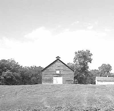 View of the exterior of Fort Dufferin stable, showing its relatively isolated setting within a meadow. © Parks Canada Agency / Agence Parcs Canada.