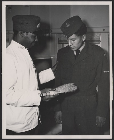 Here one of the cadets, Pat Havorka, gets a dusting-off from the CNR porter before leaving the train that brought him to Vancouver © Royal Canadian Air Force | Aviation royale canadienne / Library and Archives Canada | Bibliothèque et Archives Canada / Department of Indian Affairs and Northern Development fonds | fonds du ministère des Affaires indiennes et du Nord canadien /e011307390