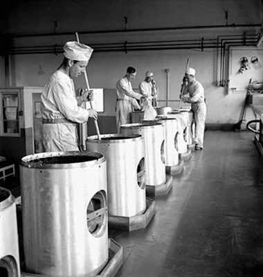 Workmen stirring chemicals used in the manufacture of warheads in the Cherrier or Bouchard plants of the Defense Industries Limited. July 1944 © Harry Rowed / Office national du film du Canada. Photothèque / Bibliothèque et Archives Canada |National Film Board of Canada. Photothèque / Library and Archives Canada